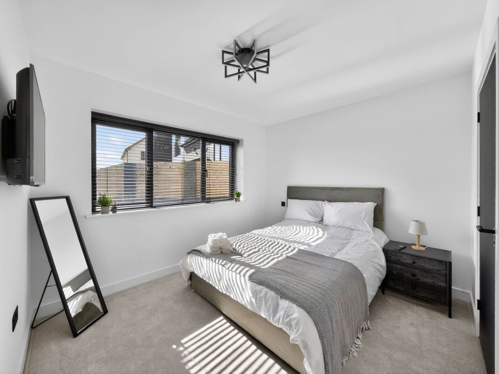 A bedroom with a bed and nightstand at Heddfan in Carmarthen