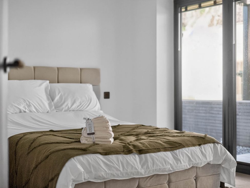 A bedroom with a bed and towels at Heddfan in Carmarthen