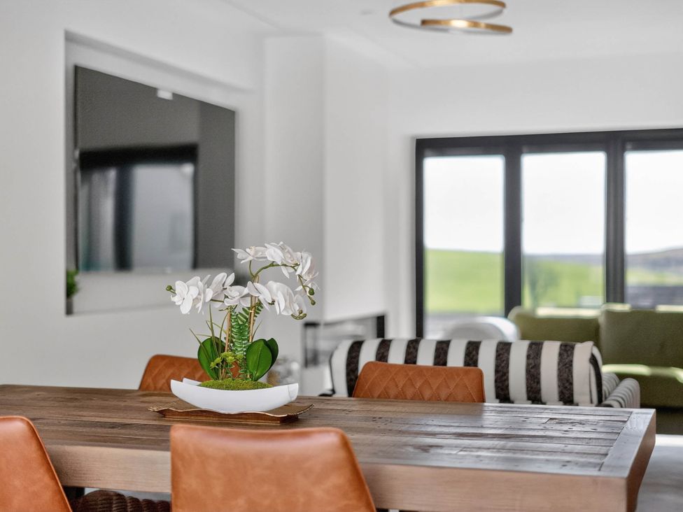A dining room with a table and chairs at Heddfan in Carmarthen