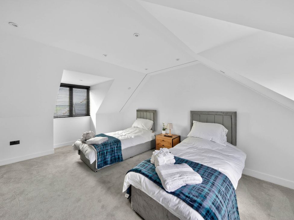 A bedroom with two beds and a window at Heddfan in Carmarthen