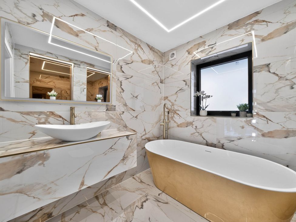 A bathroom with a bathtub and sink at Heddfan in Carmarthen