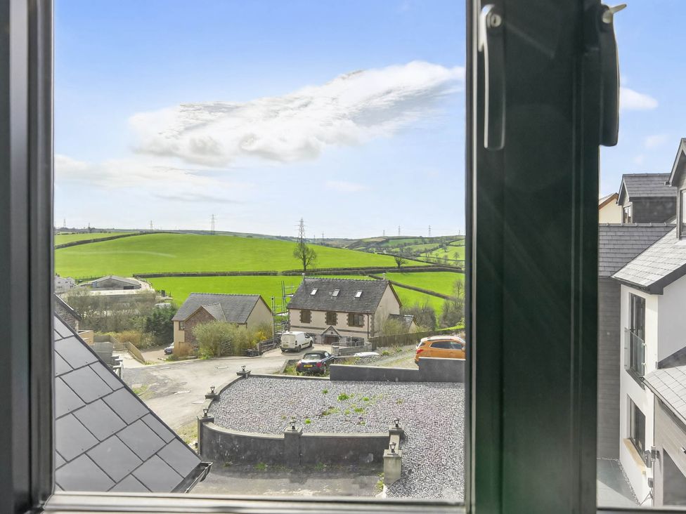 A view from a window showing countryside with houses and a road at Heddfan in Carmarthen
