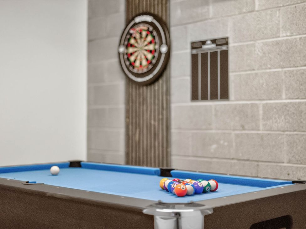 A game room with a pool table and dartboard at Heddfan in Carmarthen