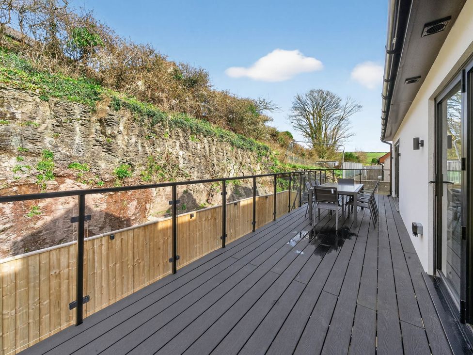 An outdoor deck with a table and chairs at Heddfan in Carmarthen