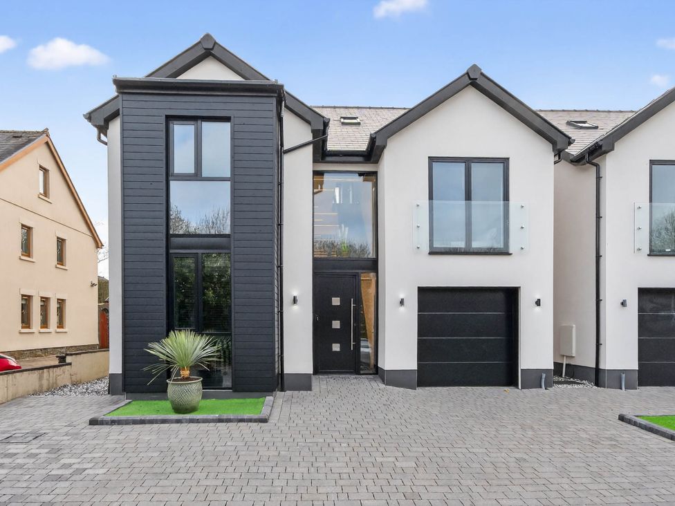 A modern house with a garage and large windows at Ty Uchel 
