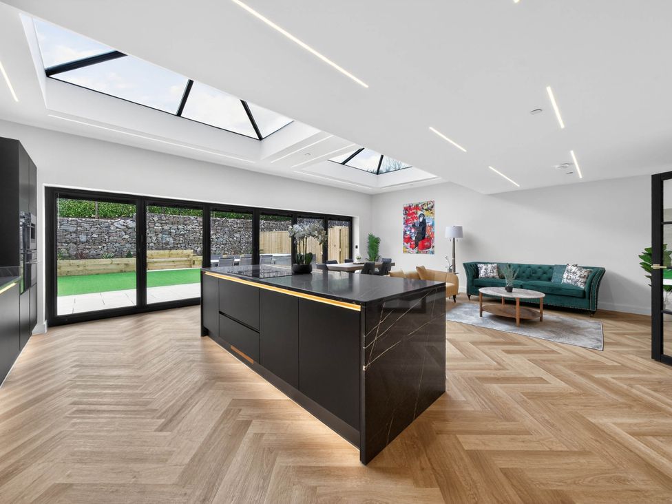 A kitchen with a large island and sliding doors at Ty Uchel