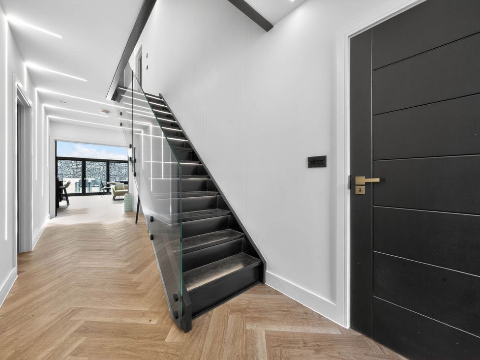 A hallway with a staircase and a window at Ty Uchel