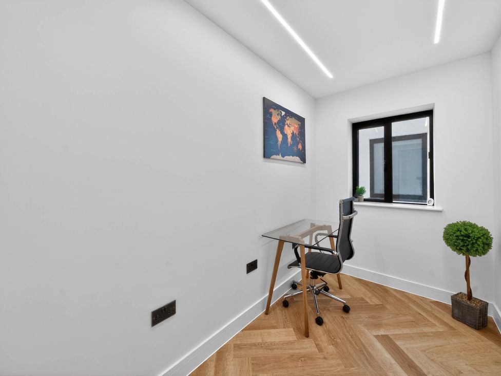 A home office with a desk, chair, and map at Ty Uchel