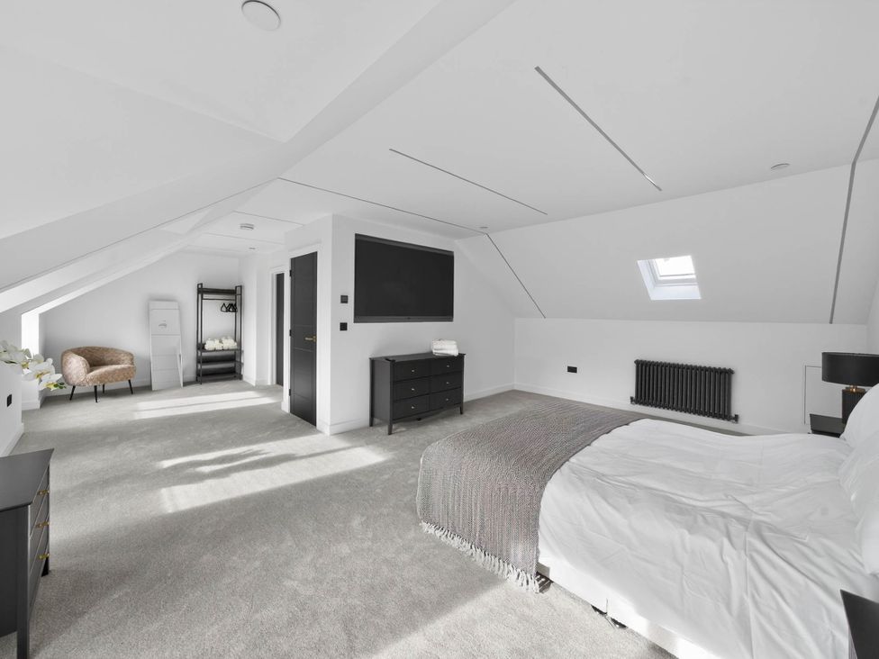 A bedroom with a bed and dresser at Ty Uchel