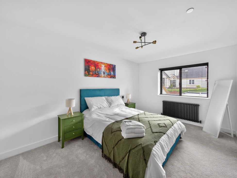 A bedroom with a bed and bedside tables at Ty Uchel