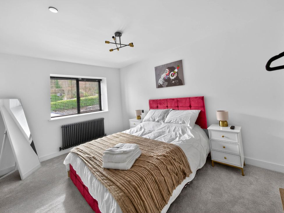 A bedroom with a bed and nightstand at Ty Uchel