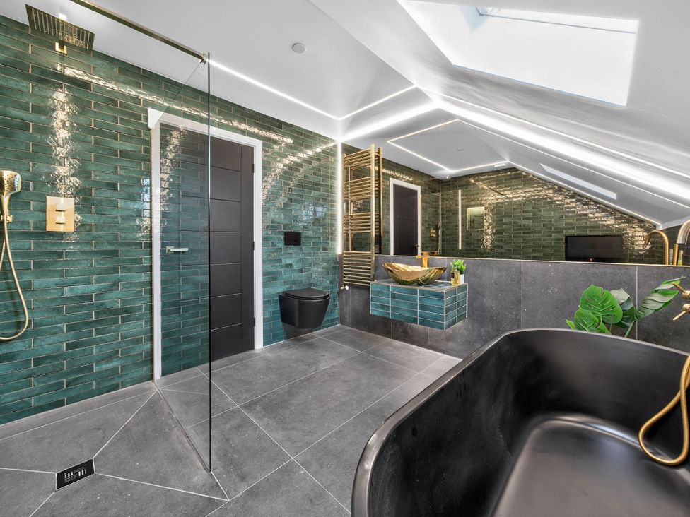 A bathroom with a shower, toilet, and sink at Ty Uchel