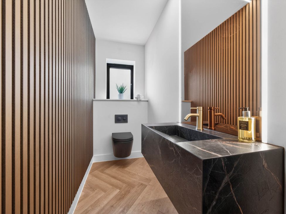 A bathroom featuring a sink and toilet at Ty Uchel