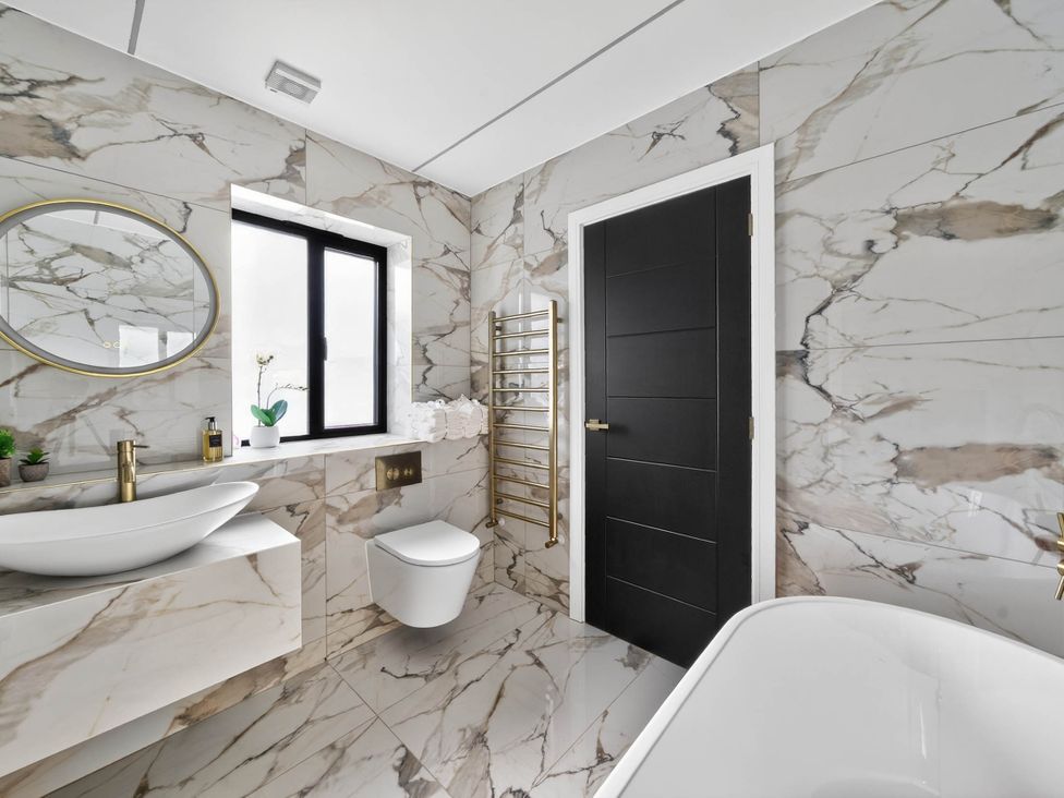 A bathroom with a bathtub, sink, and toilet at Ty Uchel