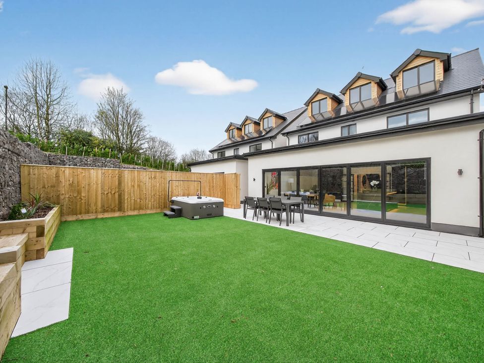 A garden with a hot tub and seating area at Ty Uchel