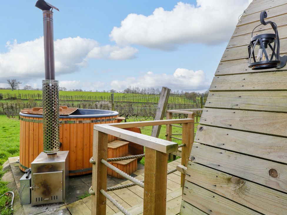 A hot tub with a chimney and wooden deck at Grape Escape near Halesworth
