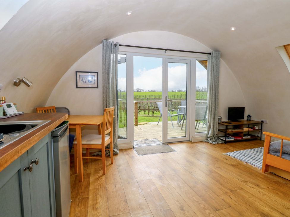 A living room with a table and chairs at Grape Escape near Halesworth