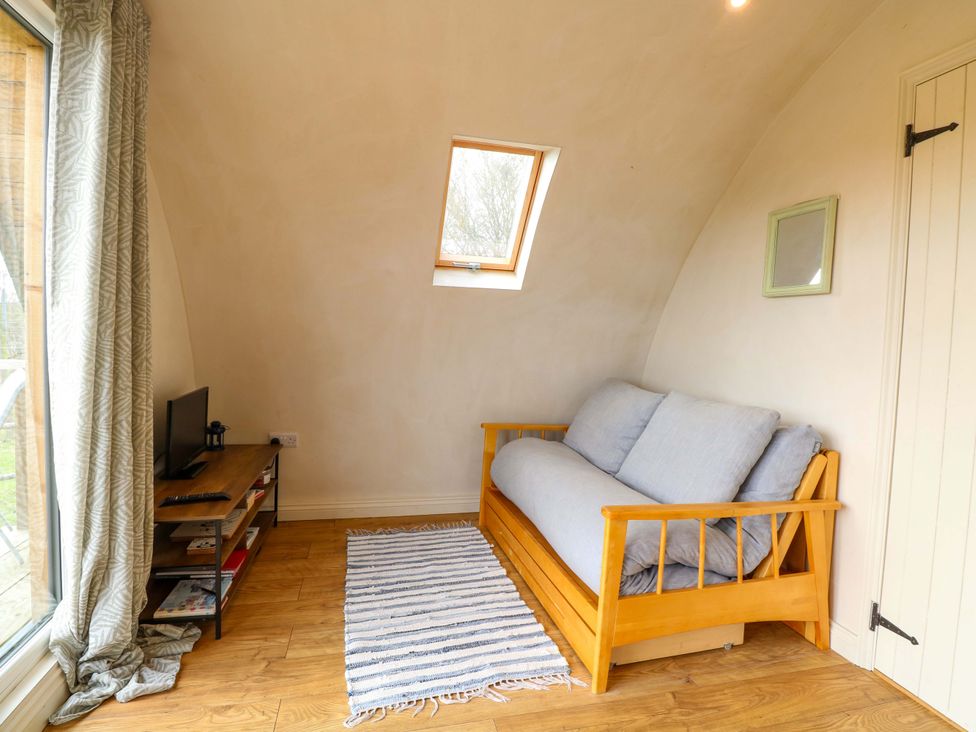 A living room with a sofa and a television at Grape Escape near Halesworth