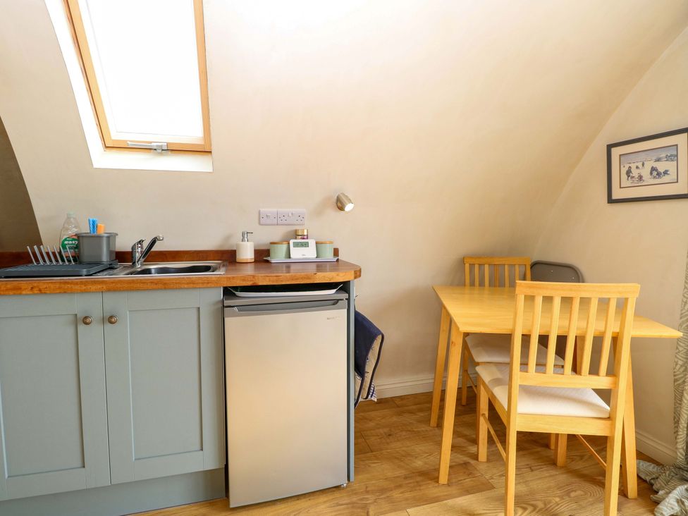 A kitchen with a sink and table at Grape Escape near Halesworth