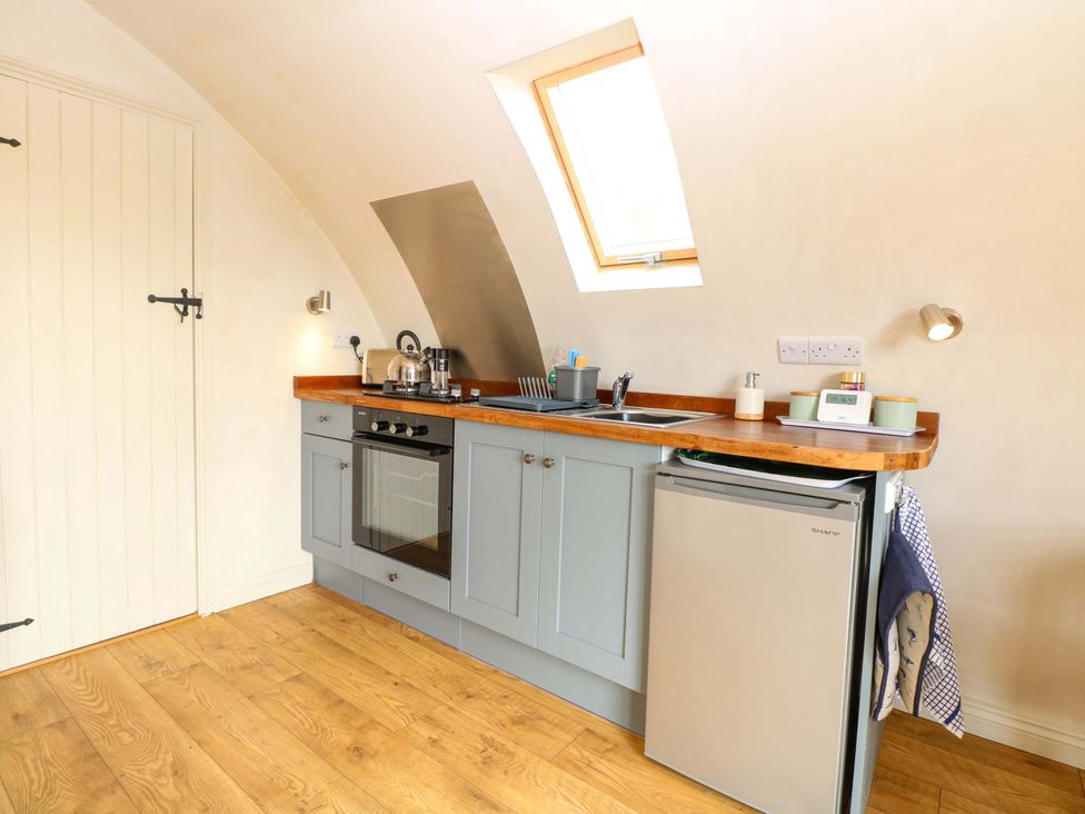 A kitchen with oven and fridge at Grape Escape near Halesworth