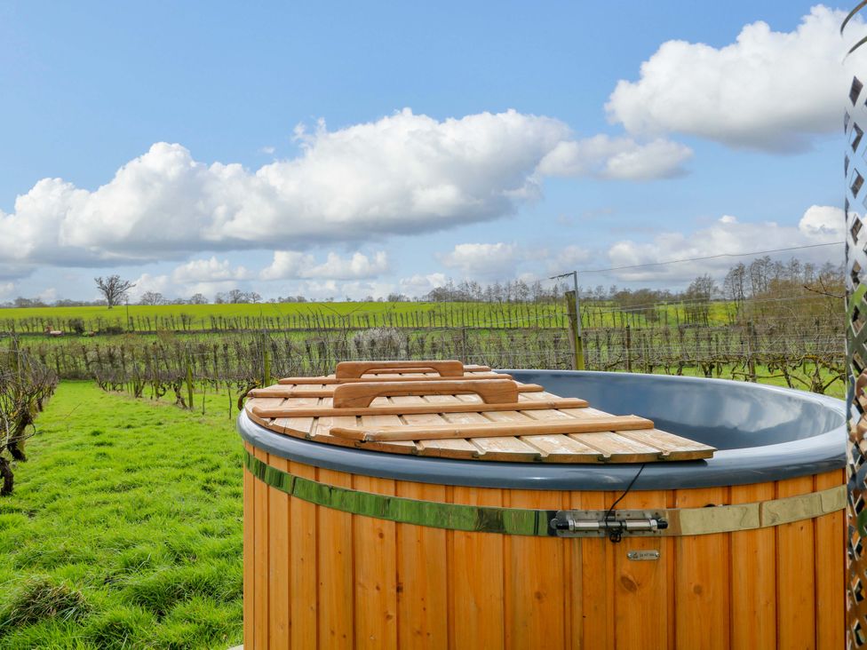 A hot tub with a wooden cover in a vineyard near Halesworth