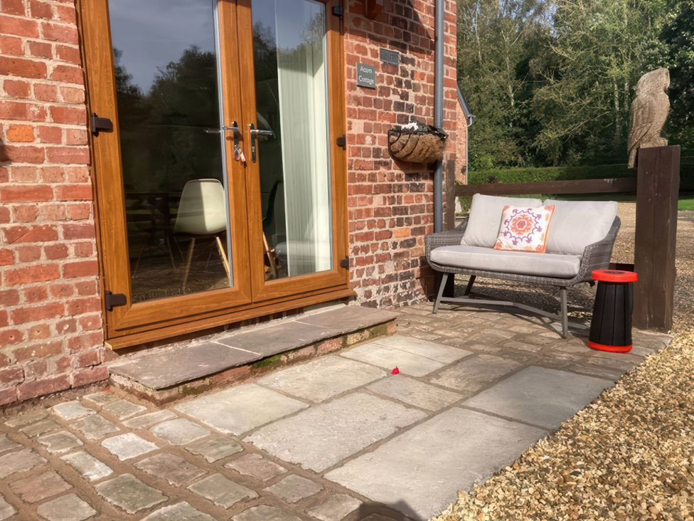 An outdoor area with a sofa and table at Acorn Cottage in Knutsford