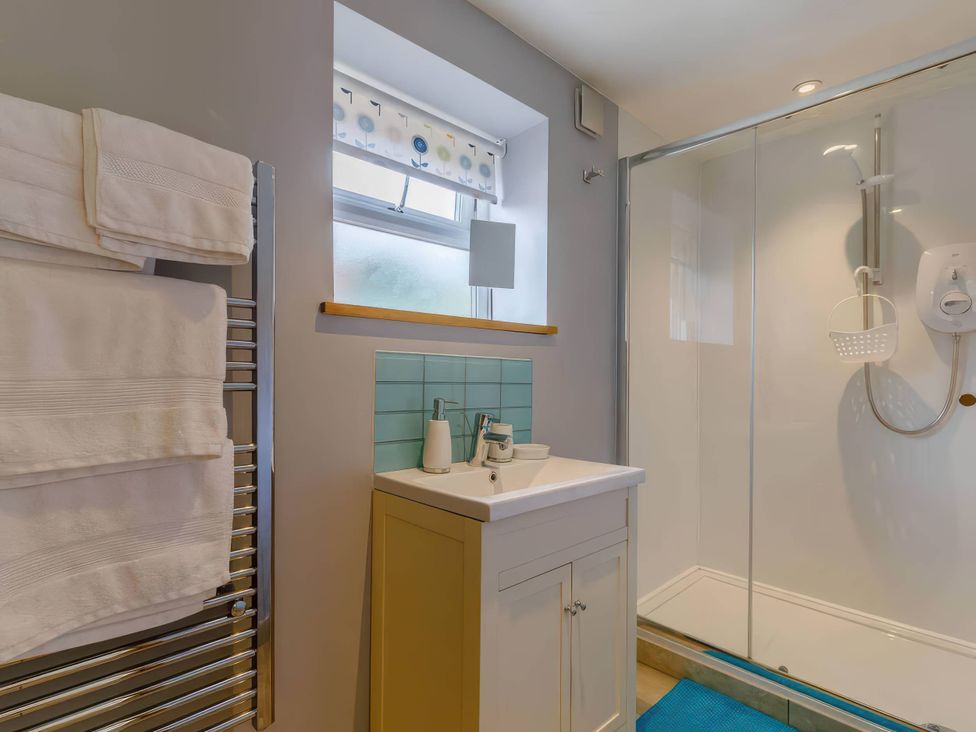 A bathroom with a sink and shower at Acorn Cottage in Knutsford