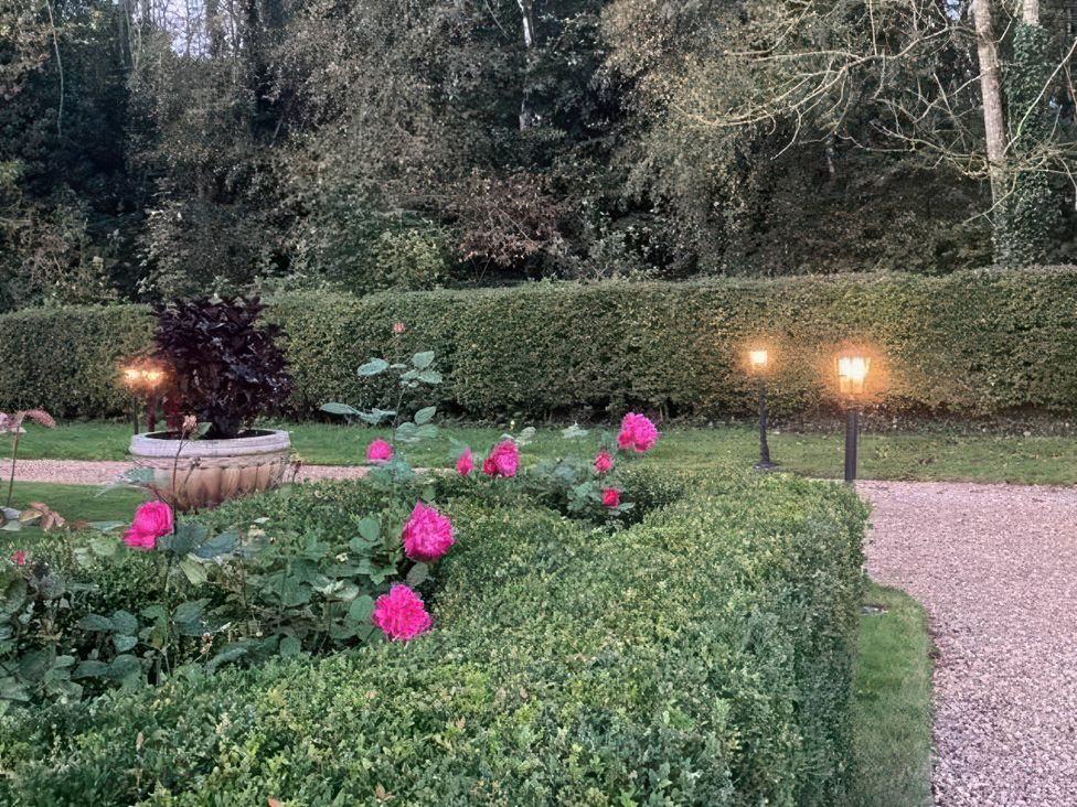 A garden with flowers and lanterns at Acorn Cottage in Knutsford