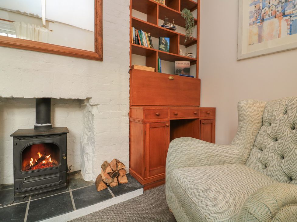 A living room with a fireplace and bookshelf at Ivy Cottage Dartmouth