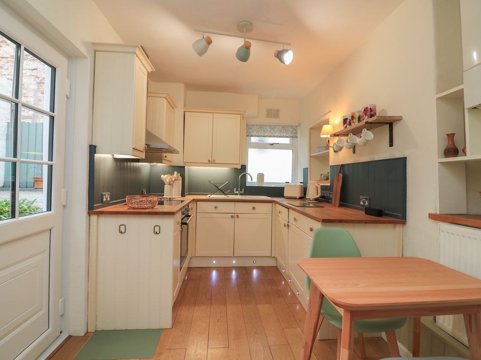 A kitchen with cabinets and countertop at Ivy Cottage in Dartmouth