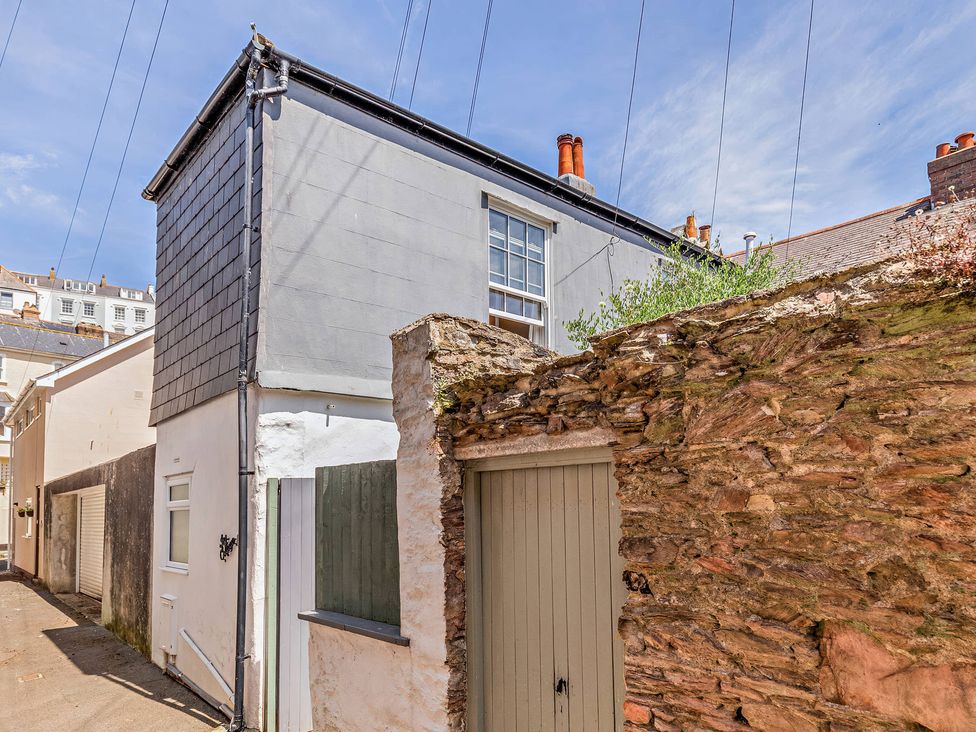 A building with a window and door in an outdoor alley at Ivy Cottage Dartmouth