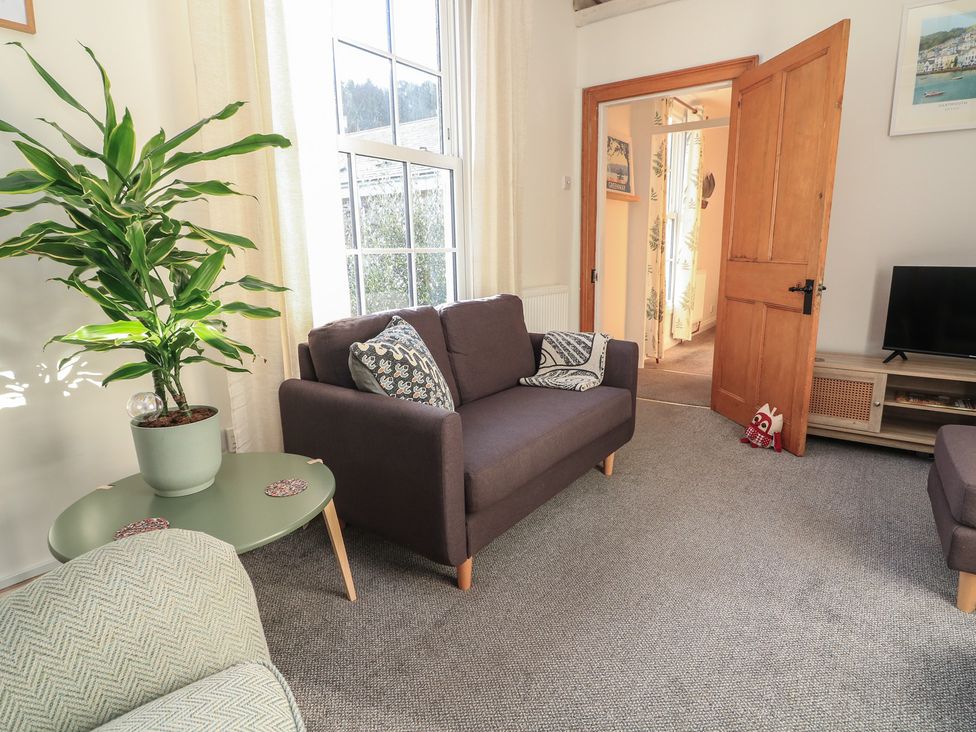 A living room with a sofa and a plant at Ivy Cottage in Dartmouth