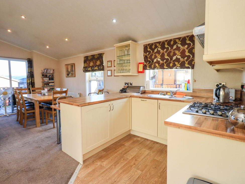 A kitchen with a dining area and various appliances at Kingfisher Lodge