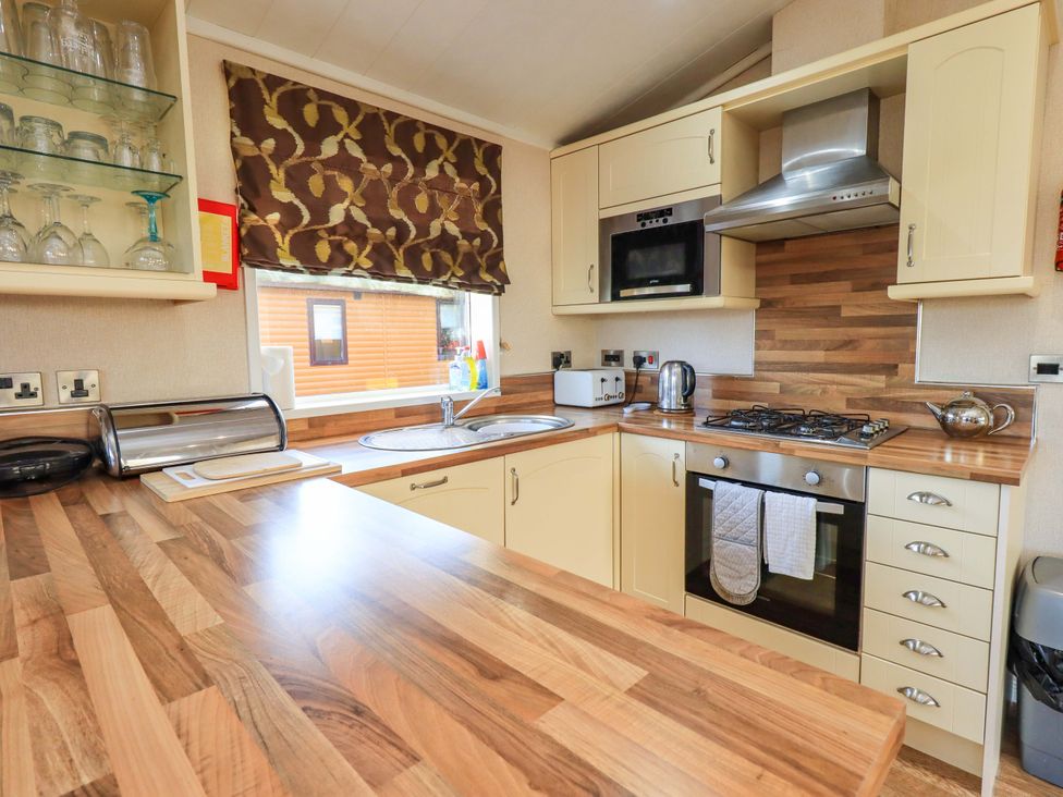 A kitchen with a cooking stove and sink at Kingfisher Lodge