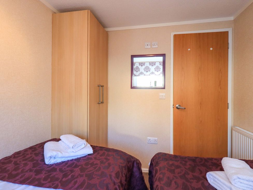 A bedroom with a bed and wardrobe at Kingfisher Lodge
