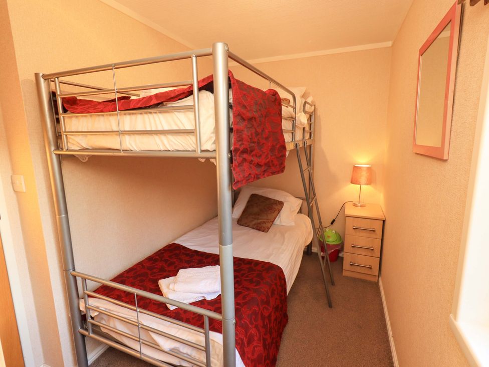 A bedroom with a bunk bed and bedside table at Kingfisher Lodge 