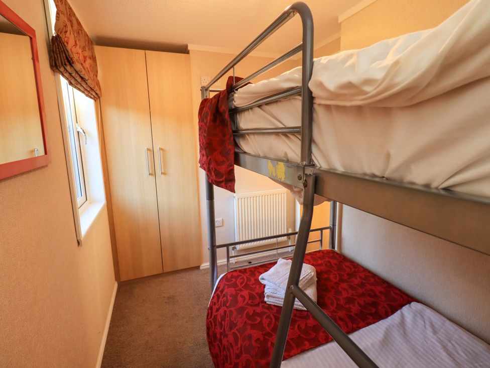 A bedroom with a bunk bed and wardrobe at Kingfisher Lodge 