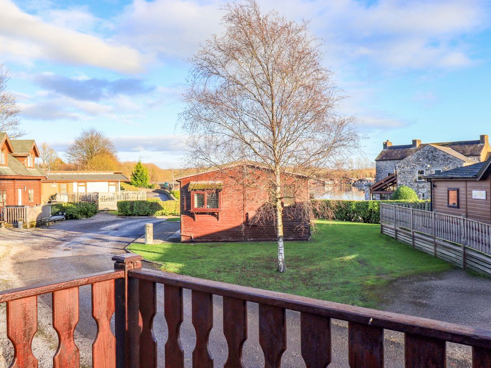 An outdoor view of cabins and a tree at Kingfisher Lodge