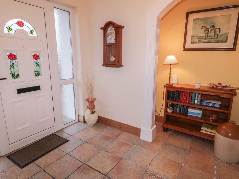 A hallway with a front door and a clock at Bungalow Falcarragh, Falcarragh, County Donegal