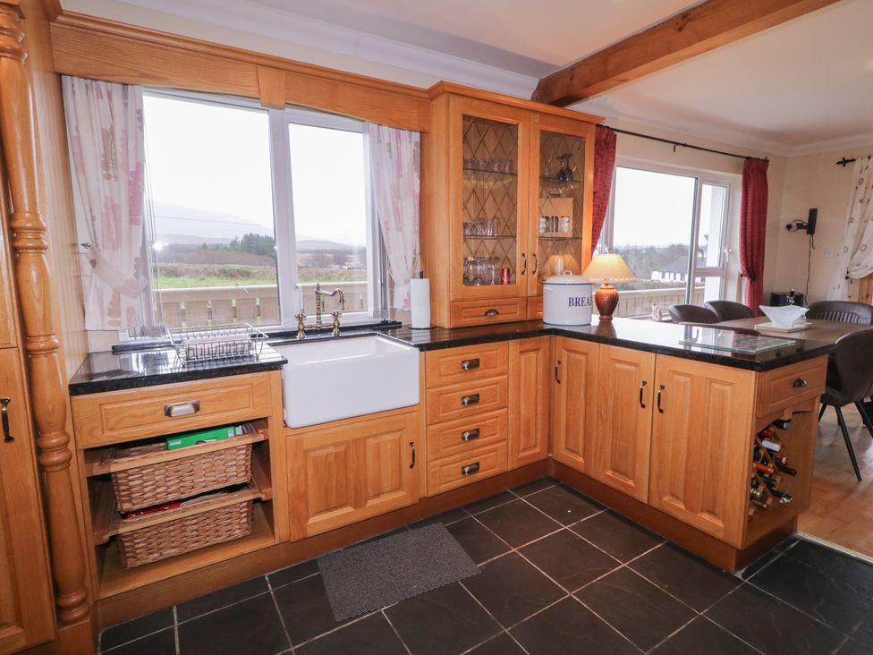 A kitchen with wooden cabinets and a sink at Bungalow Falcarragh in Falcarragh, County Donegal