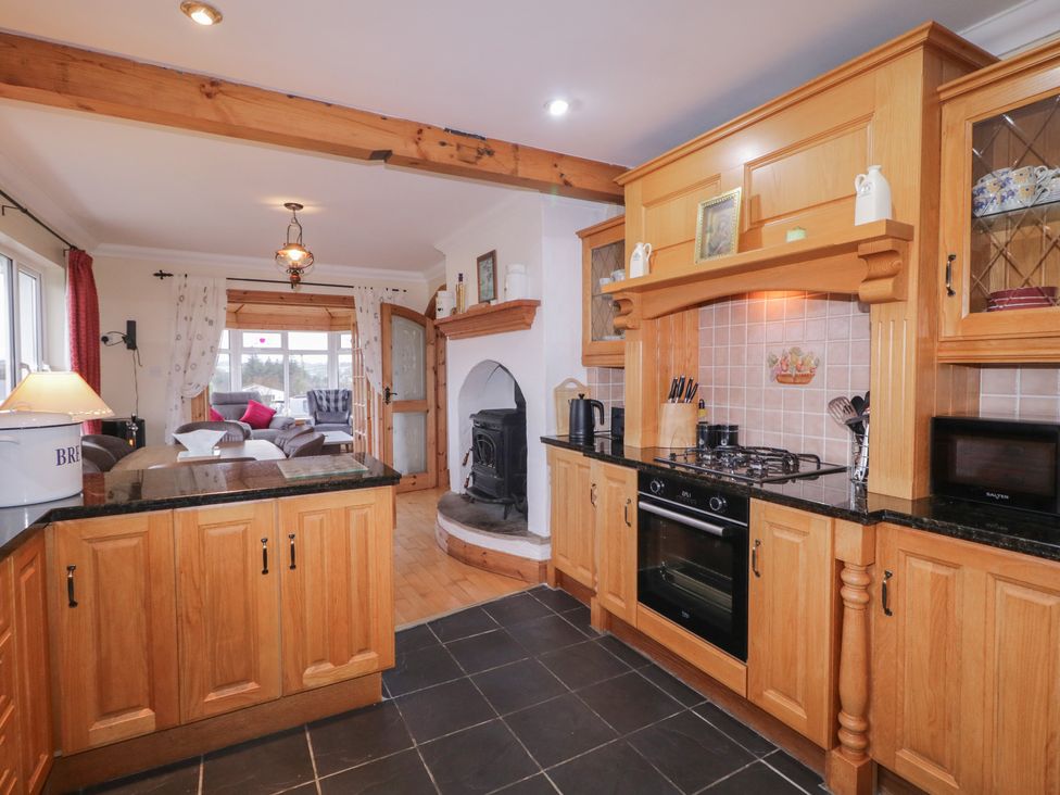 A kitchen with wooden cabinets and appliances at Bungalow Falcarragh in Falcarragh, County Donegal