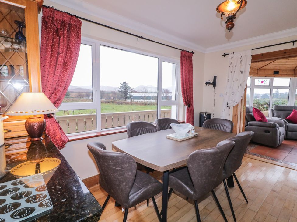 A dining room with a table and chairs with a view at Bungalow Falcarragh in Falcarragh, County Donegal