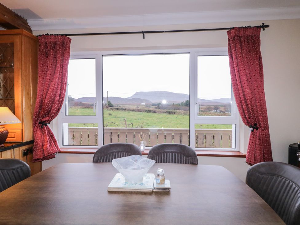 A dining room with a table and chairs and a view of the landscape at Bungalow Falcarragh in Falcarragh, County Donegal