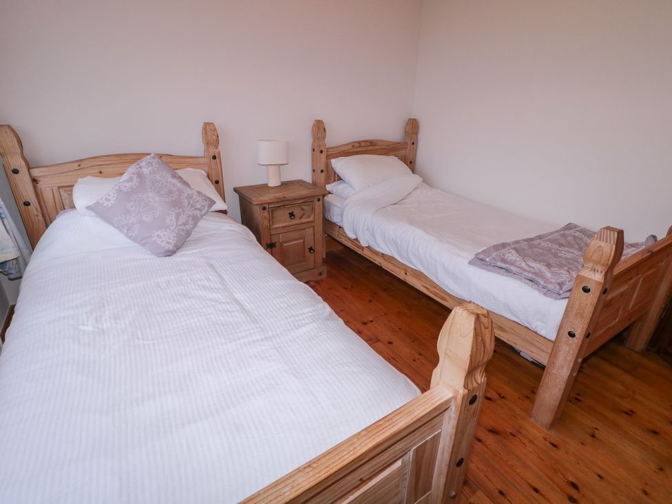 A bedroom with two beds and a nightstand at Bungalow Falcarragh in Falcarragh, County Donegal