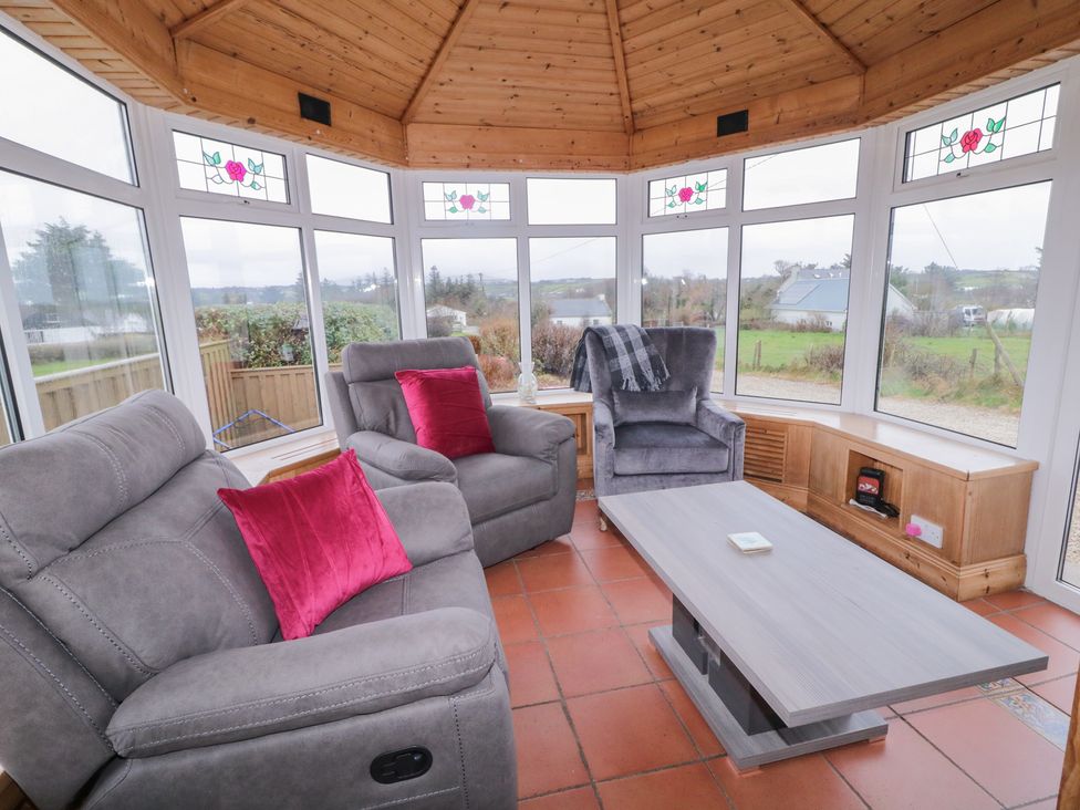 A conservatory with a sofa and recliner at Bungalow Falcarragh in Falcarragh, County Donegal