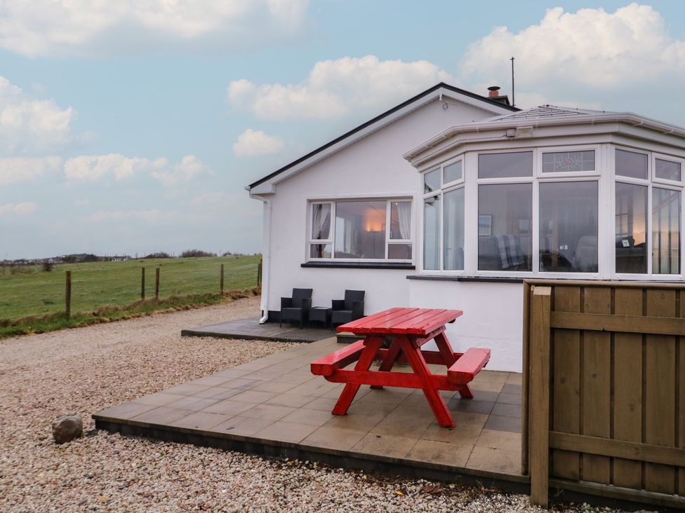 An outdoor area with a red picnic table and chairs at Bungalow Falcarragh in Falcarragh, County Donegal