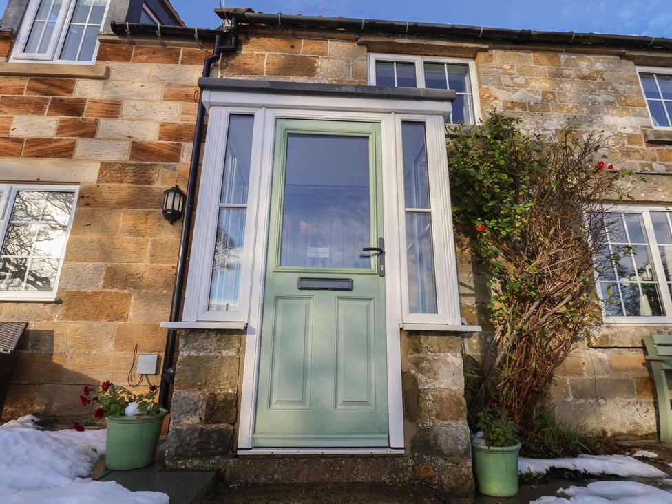 A front door with windows and plants at Cheyne Cottage in Fylingthorpe