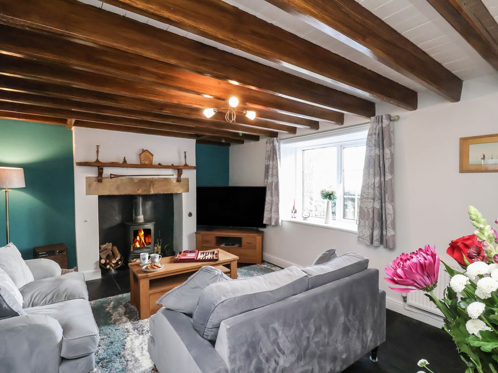 A living room with a fireplace and sofa at Cheyne Cottage in Fylingthorpe