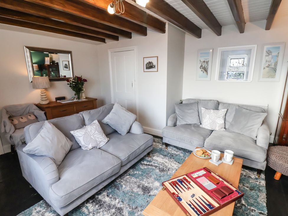 A living room with sofas and a table at Cheyne Cottage in Fylingthorpe