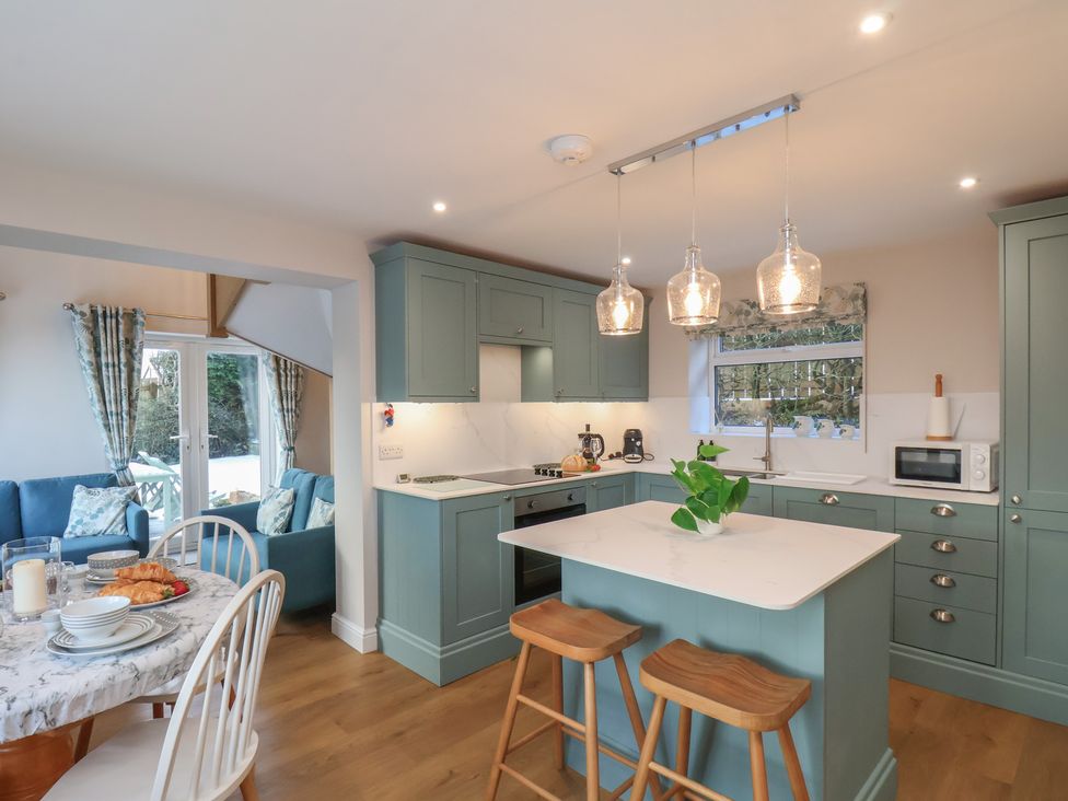 A kitchen with stools and table at Cheyne Cottage in Fylingthorpe